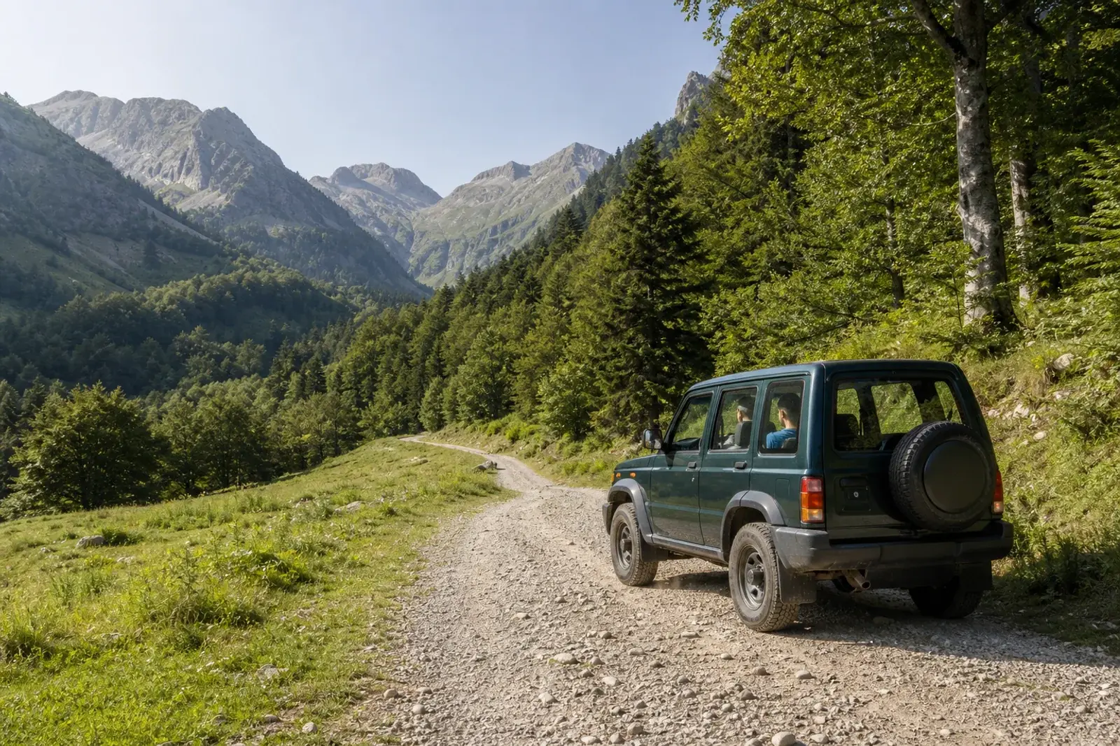Vehículo 4x4 en una pista de montaña del Val d'Aran en verano, con cumbres del Pirineo al fondo