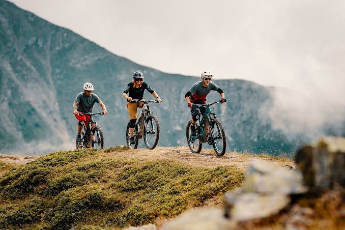 Tres ciclistas recorren un sendero de montaña