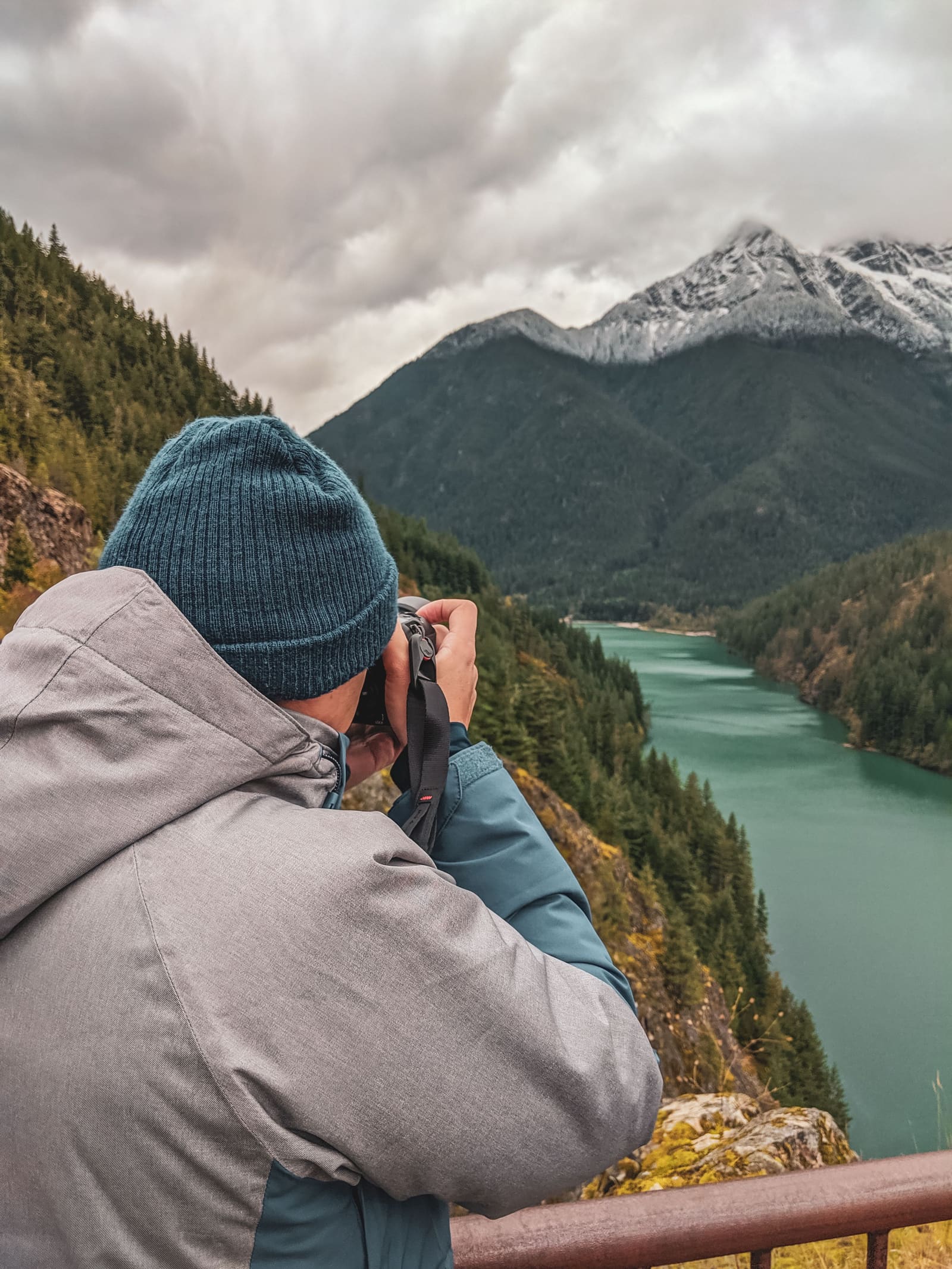 Fotografo de naturaleza encuadrando un embalse de montaña rodeado de bosque en los Pirineos