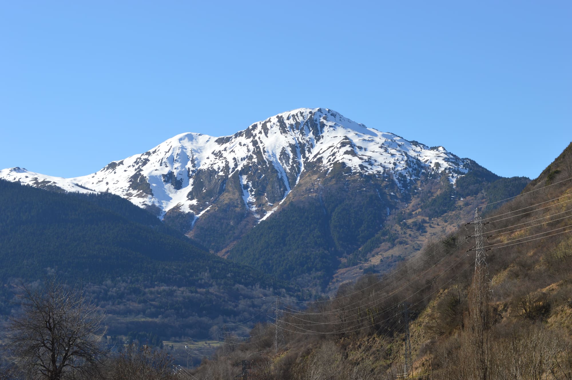 Cima del Montcorbison nevada vista desde el valle, con el pueblo de Vielha al fondo