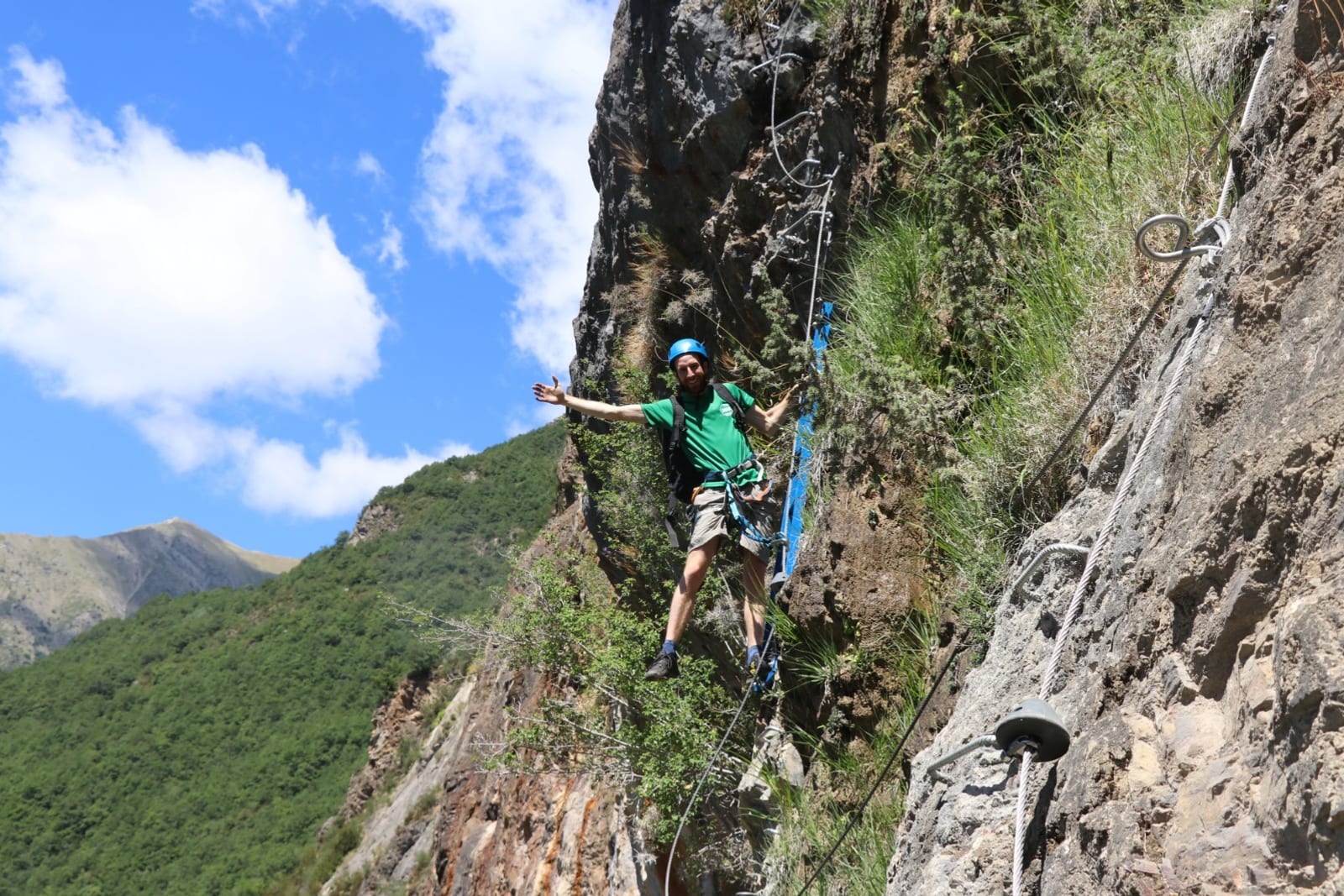 Persona en un tramo aéreo de la via ferrata de Roca Carrera, sobre Barruera, con la Vall de Boi al fondo