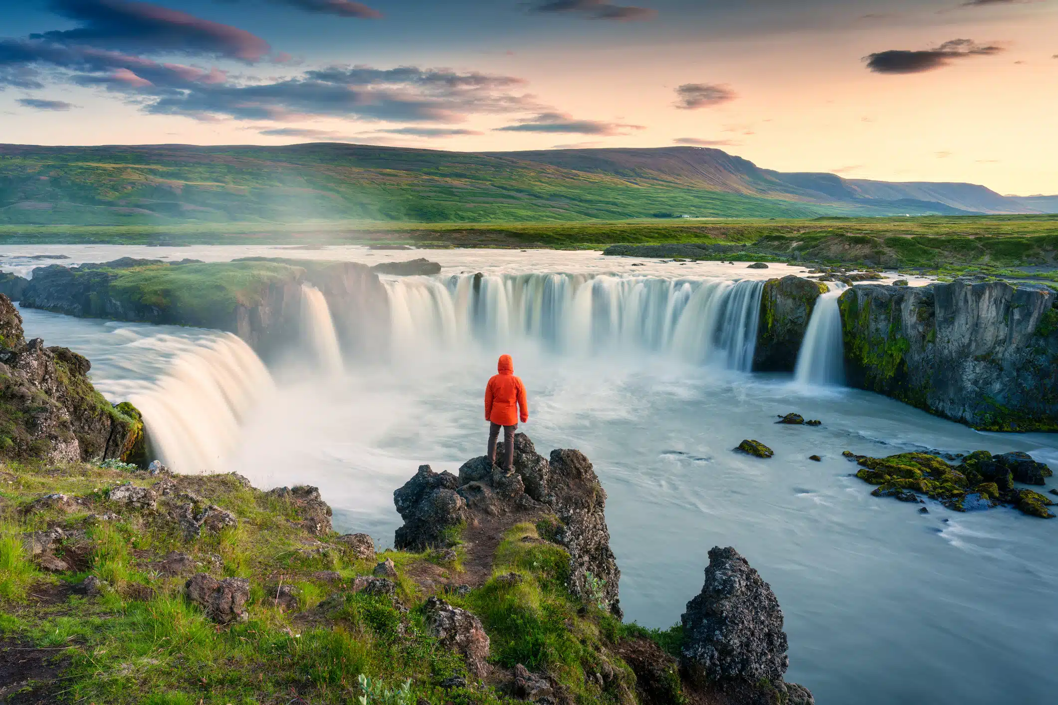 Viajera ante una gran cascada en el paisaje volcánico de Islandia