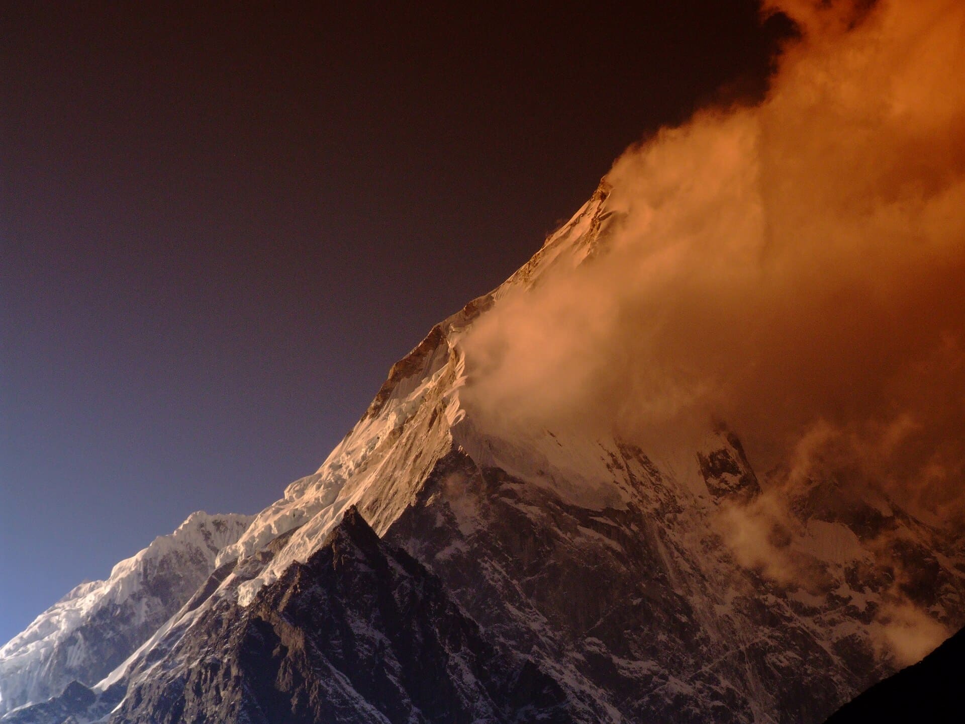 El Langtang Lirung (7.227 m) al atardecer, con nubes anaranjadas sobre la cumbre nevada