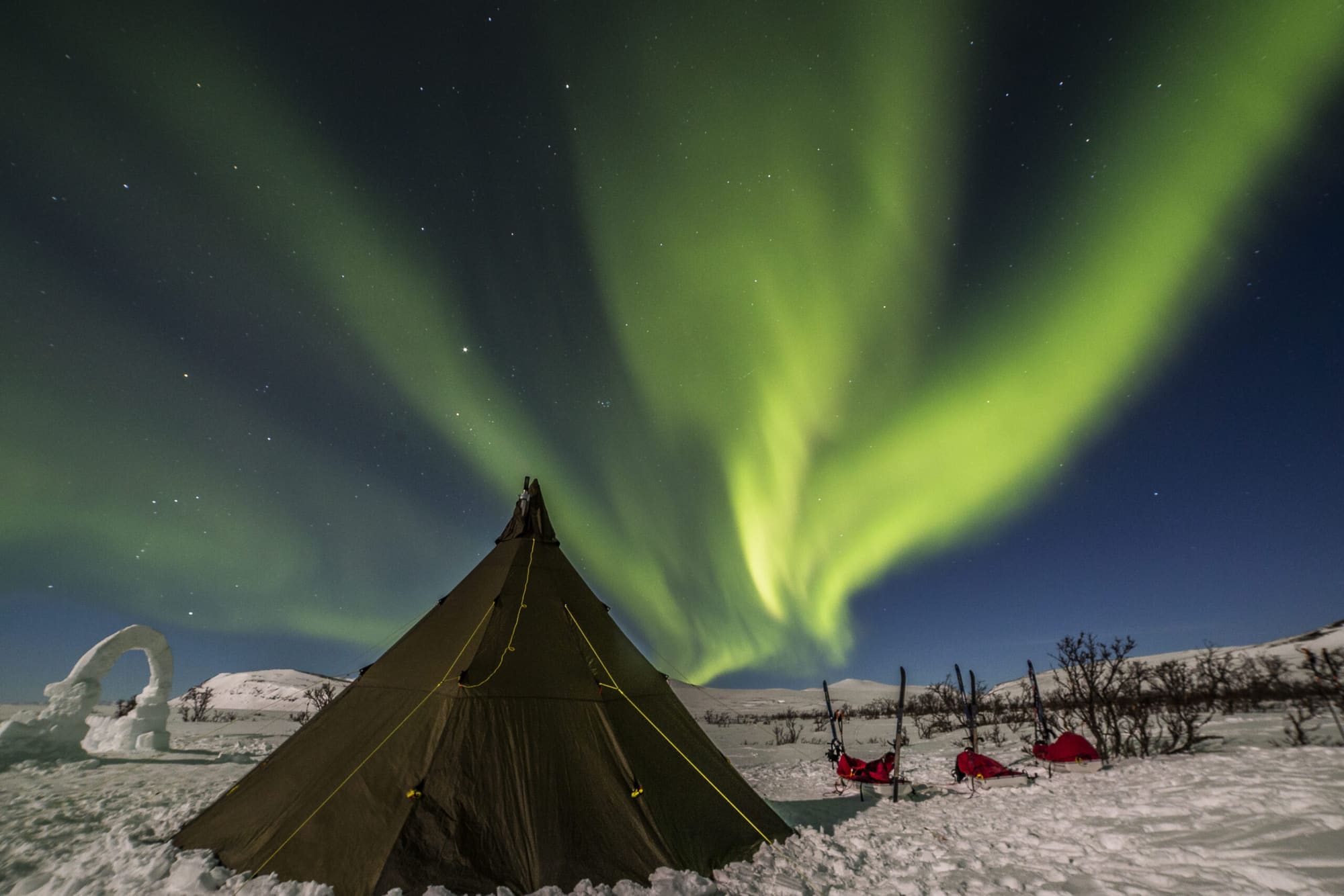 Aurora boreal sobre un campamento de tipis en Laponia